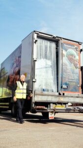 Greencore delivery vehicle being unloaded at a distribution site by a colleague wearing high-visibility clothing.