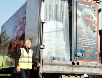 Greencore delivery vehicle being unloaded at a distribution site by a colleague wearing high-visibility clothing.